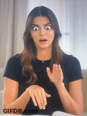 A Woman In A Black Shirt Is Making A Funny Face GIF