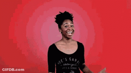A Woman In A Black Shirt Is Making A Gesture With Her Fist In The Air . GIF