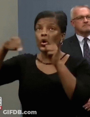 A Woman In A Black Shirt Is Pointing At Something GIF