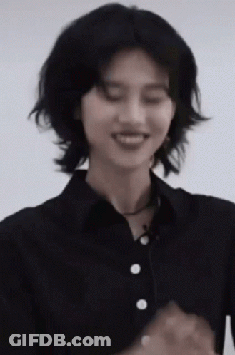 A Woman In A Black Shirt Is Smiling With Her Eyes Closed . GIF
