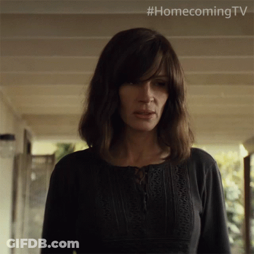 A Woman In A Black Shirt Is Standing In A Hallway With #Homecoming Tv Written Above Her GIF