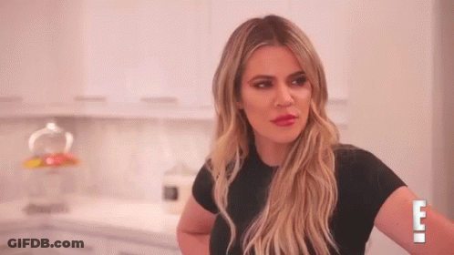 A Woman In A Black Shirt Is Standing In A Kitchen With Her Arms Crossed . GIF