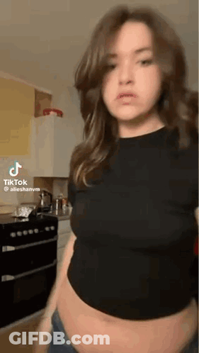 Woman In Kitchen With Exposed Belly GIF