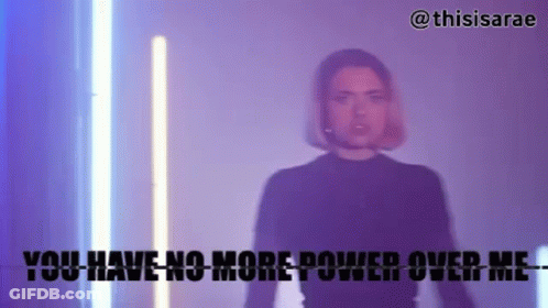 A Woman In A Black Shirt Is Standing In Front Of A Neon Light And Says You Have No More Power Over Me . GIF