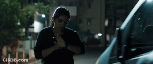A Woman In A Black Shirt Is Standing Next To A Van GIF