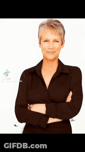 A Woman In A Black Shirt Is Standing With Her Arms Crossed On A White Background . GIF
