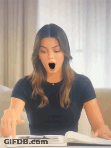 A Woman In A Black Shirt Is Yawning While Reading A Book GIF