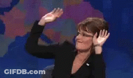 A Woman In A Black Suit Is Dancing On A Stage . GIF