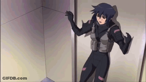 A Woman In A Black Suit Is Standing In A Room GIF