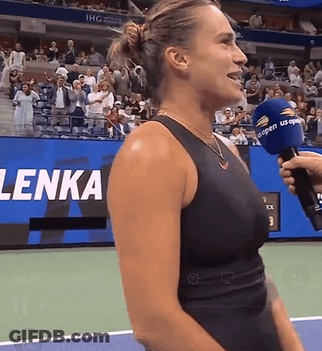 A Woman In A Black Tank Top Is Being Interviewed By A Man With A Microphone That Says Us Open On It GIF