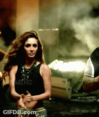 A Woman In A Black Tank Top Is Dancing Next To A Man In A Black Shirt With The Word Mehc On It GIF