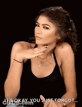 A Woman In A Black Tank Top Is Making A Funny Face While Holding Her Hand To Her Face . GIF