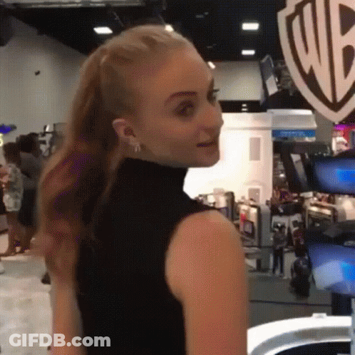 A Woman In A Black Tank Top Is Standing In Front Of A Wb Logo GIF