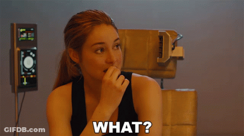 A Woman In A Black Tank Top With The Word What On Her Chest GIF