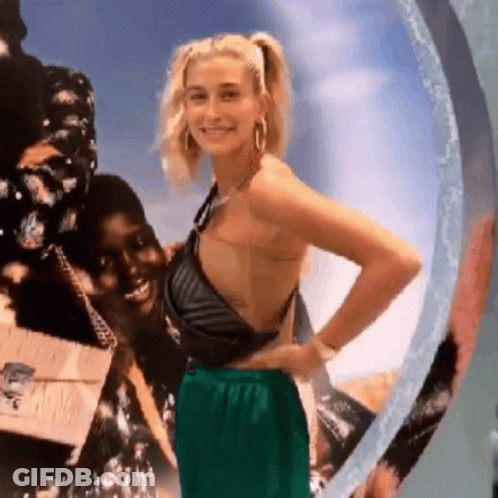 A Woman In A Black Top And Green Pants Is Standing Next To A Woman In A Black Top And Green Pants . GIF