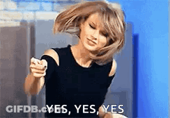 A Woman In A Black Top Is Pointing At The Camera And Saying Yes . GIF