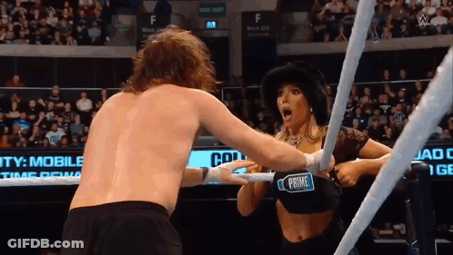 A Woman In A Black Top With The Word Prime On It Is Wrestling A Man In A Ring GIF