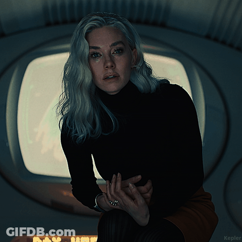 A Woman In A Black Turtleneck Stands In Front Of A Window With The Word Kepler On The Bottom Right GIF