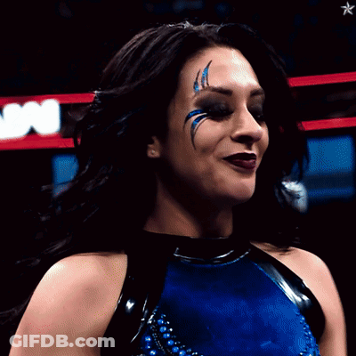 A Woman In A Blue And Black Outfit With A Star In The Background GIF