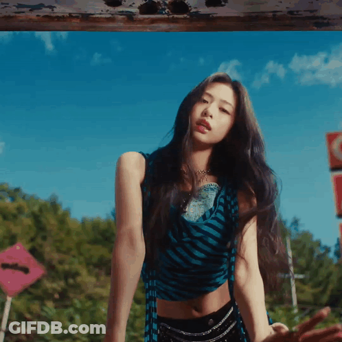 A Woman In A Blue And Black Striped Crop Top And Black Shorts GIF