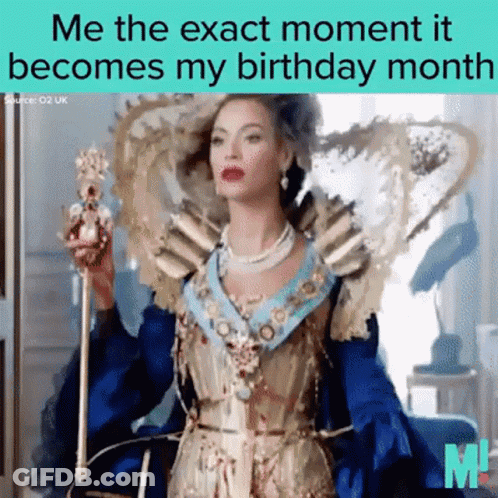 A Woman In A Blue And Gold Dress Holding A Crown GIF