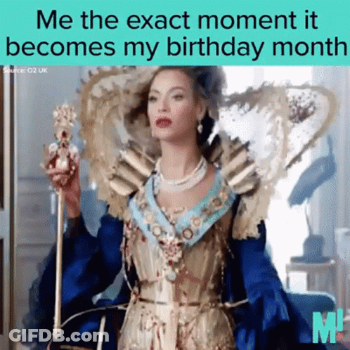 A Woman In A Blue And Gold Dress Is Holding A Crown GIF