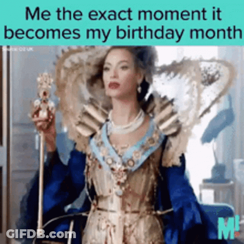 A Woman In A Blue And Gold Dress Is Holding A Crown GIF