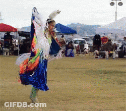 A Woman In A Blue And Orange Dress Is Dancing GIF