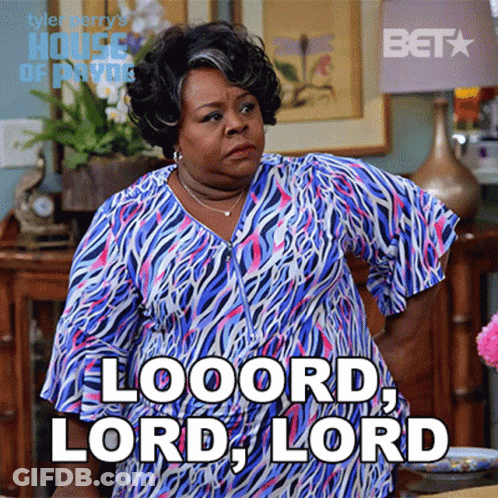 A Woman In A Blue And Pink Zebra Print Dress Is Standing In A Living Room And Says Looord Lord Lord GIF