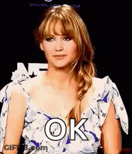 A Woman In A Blue And White Dress Is Making A Funny Face And Saying `` Ok '' . GIF