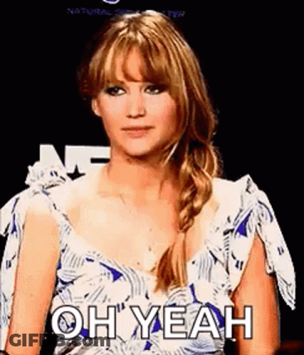 A Woman In A Blue And White Dress Is Making A Funny Face . GIF