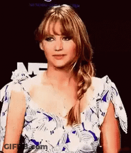 A Woman In A Blue And White Dress With A Braid Is Making A Funny Face . GIF
