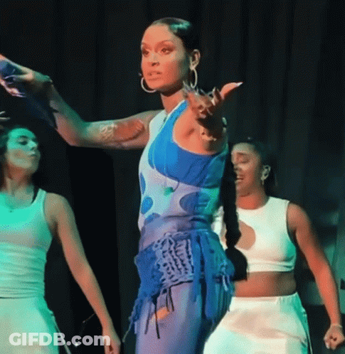 A Woman In A Blue And White Outfit Is Dancing On Stage GIF
