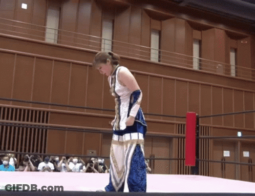 A Woman In A Blue And White Outfit Is Standing On A Ring GIF