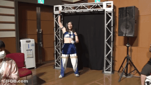 A Woman In A Blue And White Outfit Stands In A Room GIF