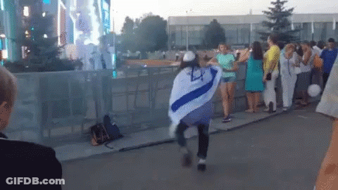 A Woman In A Blue And White Striped Shirt Is Dancing In Front Of A Crowd GIF