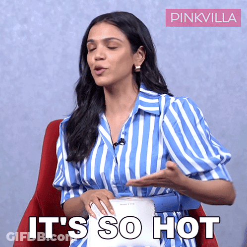 A Woman In A Blue And White Striped Shirt Is Sitting In A Red Chair And Says It 'S So Hot GIF