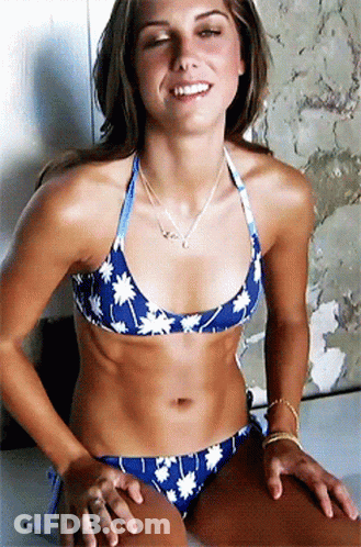 A Woman In A Blue Bikini With White Flowers On It Smiles GIF
