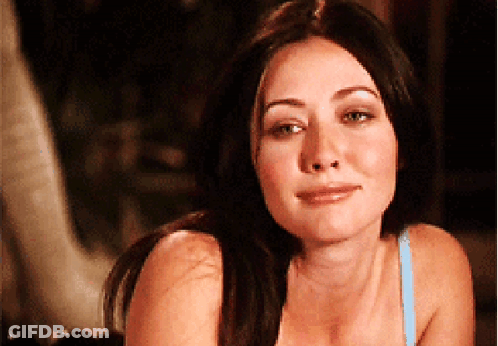 A Woman In A Blue Bra Looks At The Camera With A Smile On Her Face GIF