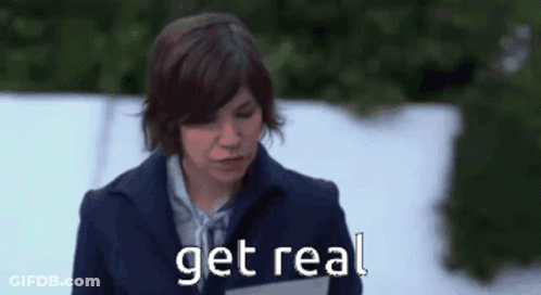 A Woman In A Blue Coat Is Standing In The Snow And Says Get Real GIF