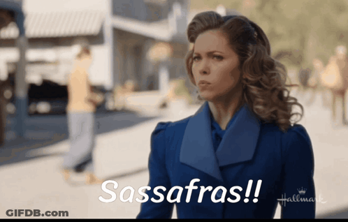A Woman In A Blue Coat Says Sassafras On A Hallmark Ad GIF