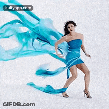 A Woman In A Blue Dress And High Heels Is Dancing With A Blue Cloth . GIF