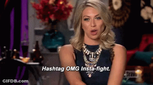 A Woman In A Blue Dress And Necklace Is Talking About Hashtags And Insta-Fights . GIF