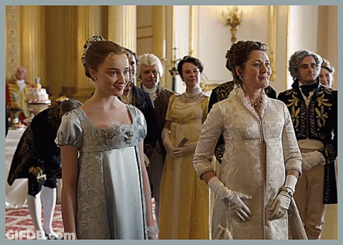 A Woman In A Blue Dress And White Gloves Stands Next To A Woman In A White Dress GIF
