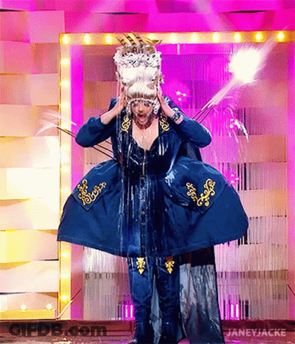 A Woman In A Blue Dress And Wig Is Standing On A Stage With Water Coming Out Of Her Ears . GIF