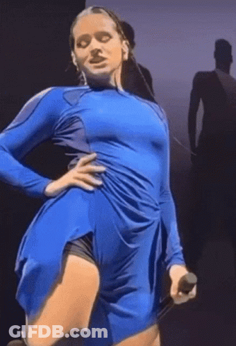 A Woman In A Blue Dress Holds A Microphone In Her Hand GIF