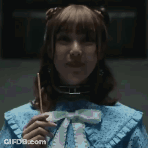 A Woman In A Blue Dress Holds A Stick In Her Hand GIF