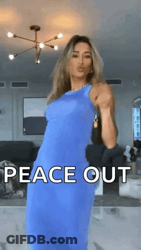 A Woman In A Blue Dress Is Dancing In A Living Room With The Words Peace Out Written On The Screen . GIF