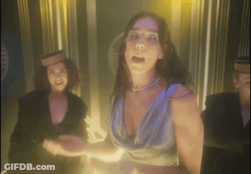 A Woman In A Blue Dress Is Dancing In Front Of A Man GIF