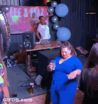 A Woman In A Blue Dress Is Dancing In Front Of A Sign That Says Lee & Plaza GIF